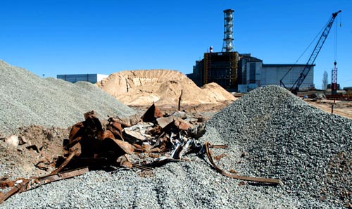 Před stavbou nových struktur zbavují inženýři místo kontaminovaných zbytků, jako je tento kov. Vysoce radioaktivní zařízení a stavební odpady byly v průběhu předchozích sanací zakopány do písku a štěrku kolem elektrárny.